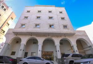a large building with cars parked in front of it at فندق ام جي كراون 3 - MG Crown Hotel 3 in Medina