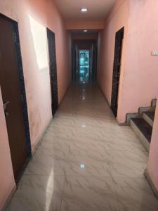 an empty corridor in a building with pink walls and a long hallway at Kadaiya house in Marwad