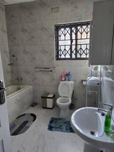 a bathroom with a sink and a toilet and a tub at T&M Estates Lusaka in Chilanga +22 photos