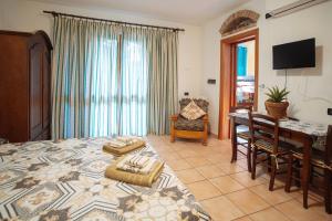 a bedroom with a bed and a table and a desk at Residenza Su Prelau in Gonnesa