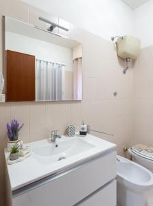 a white bathroom with a sink and a toilet at Station House Center in Cisterna di Latina +26 photos