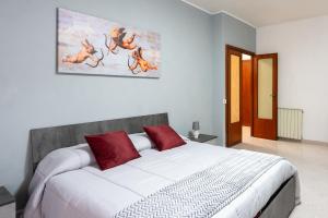 a bedroom with a large white bed with red pillows at Station House Center in Cisterna di Latina