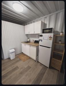 a kitchen with white cabinets and a white refrigerator at Outback Getaway Home in Mount Isa