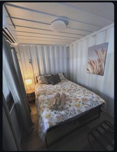 a small bedroom with a bed with a comforter at Outback Getaway Home in Mount Isa