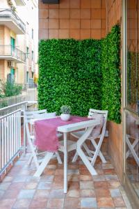 a table and chairs on a patio with a green wall at Station House Center in Cisterna di Latina
