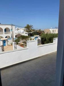 a white fence with a view of a city at Maison a midoun in Midoun