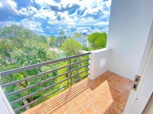 a balcony with a view of trees and clouds at Candy Hotel Can Tho in Cái Răng