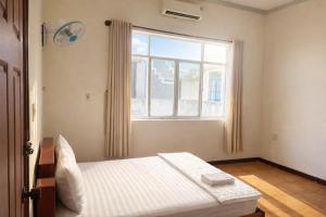a bedroom with a bed and a large window at Candy Hotel Can Tho in Cái Răng