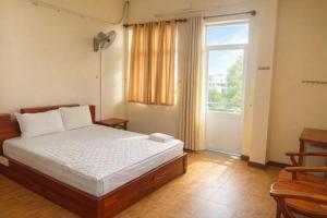a bedroom with a bed and a window at Candy Hotel Can Tho in Cái Răng
