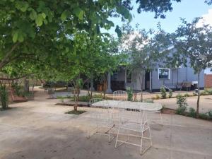 a white table and chairs sitting under a tree at 1688 BB7 Suites in Victoria Falls +2 photos