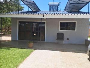 a small white house with a roof at 1688 BB7 Suites in Victoria Falls