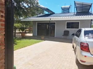 a white car parked in front of a house at 1688 BB7 Suites in Victoria Falls