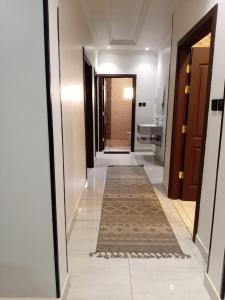 a hallway with a rug on the floor and a hallway with a bathroom at شقق سكنية بالخالدية in Al ‘Awālī +55 photos