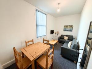 a living room with a table and a couch at Spacious Ormskirk Contractor Stay by PolkaStays in Ormskirk