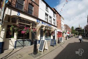 a woman walking down a street next to a building at Spacious Ormskirk Contractor Stay by PolkaStays in Ormskirk