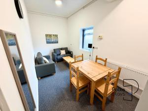 a living room with a table and a couch at Spacious Ormskirk Contractor Stay by PolkaStays in Ormskirk