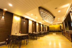 a restaurant with tables and chairs and a chandelier at Hotel Seagull in Digha