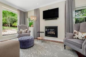 a living room with a fireplace and a tv at Manor On Main in Midrand