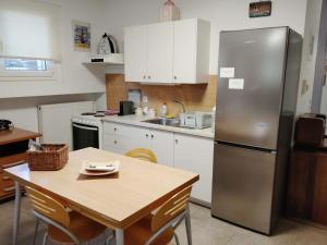 a kitchen with a table and a stainless steel refrigerator at Rodi House in Nafplio