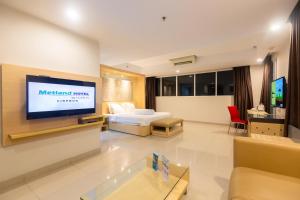 a hotel room with a bed and a tv at Metland Hotel Cirebon by Horison in Cirebon