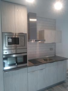una cocina con estufa y microondas en VTZ El Balcón de Las Armas RENOVADO!!! - Parking GRATIS, en Zaragoza 6 fotos más