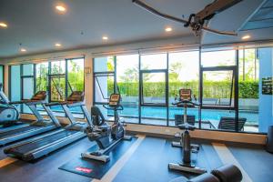 a gym with cardio machines and a swimming pool at Vista Residence Old Town in Phuket