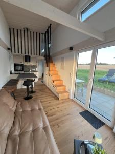 a living room with a couch and a staircase at Tinyhaus Ferien in Eggolsheim