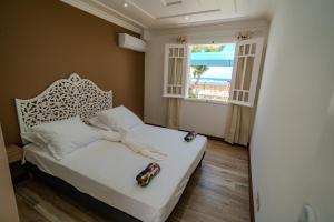 a bedroom with a white bed and a window at La Villa Bleue, Pieds dans l'eau in Saint-Leu