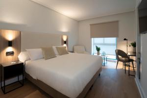 a bedroom with a large white bed and a desk at Villa Augusta Spa & Garden in Valladolid +22 photos