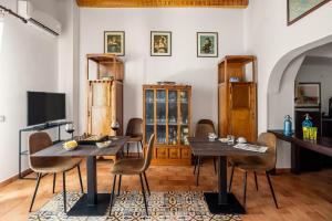 a dining room with two tables and chairs and a television at Villa Trigona in Piazza Armerina