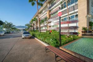 a bench next to a building with a street sign at Kaewsamui Resort in Ban Tha Phet Noi +2 photos