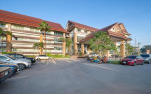 a parking lot with cars parked in front of a building at Kaewsamui Resort in Ban Tha Phet Noi