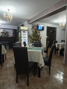 a dining room with a christmas tree on a table at Pensiunea Vânătorului in Miceşti