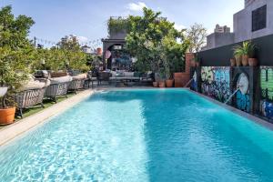 a swimming pool with blue water in a building at Quartier by Montraj Sukhumvit Bangkok in Bangkok