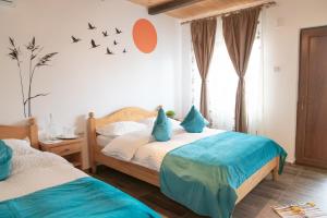 two beds in a bedroom with birds on the wall at Casa din Delta in Murighiol