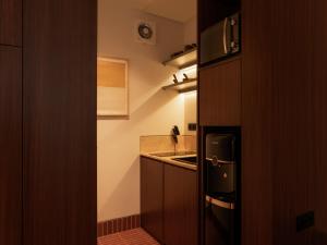 a small kitchen with a refrigerator and a sink at Brown Feather Pererenan in Canggu