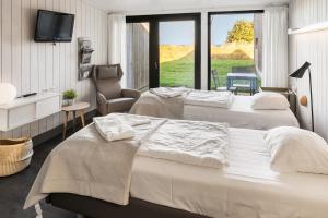 a hotel room with two beds and a chair at Musholm Holiday, Sport & Conference in Korsør
