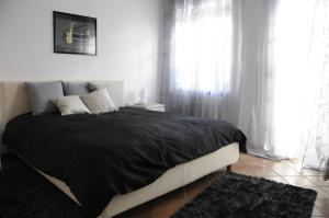 a bedroom with a large bed with black blankets and pillows at Cascina tra le vecchie vigne con piscina in Canale