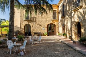 a patio with tables and chairs in front of a building at Villa Trigona in Piazza Armerina