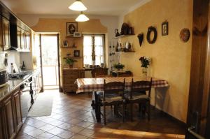 a kitchen with a table and chairs in a room at Cascina tra le vecchie vigne con piscina in Canale