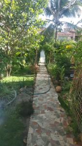 a garden with a hose on a path at Lua de Aquarius Boutique Hostel in Tamoios