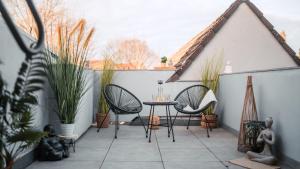 a patio with two chairs and a table with plants at FlexHome Stilvolle Ferienwohnung in Lippstadt