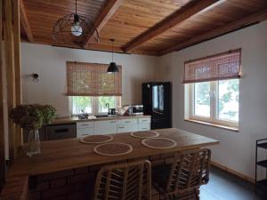 a kitchen with a wooden table and a refrigerator at Siedlisko na Roztoczu in Szastarka +23 photos