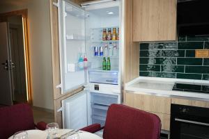 a kitchen with an open refrigerator with two red chairs at SOHO Residence in Selçuk +71 photos