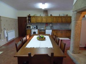 una cocina con una mesa con un bol de fruta. en Quinta Do Bento Novo - Casa de Campo - Turismo Rural, en Viana do Castelo