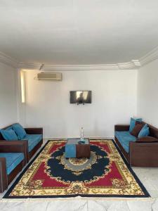 a living room with two couches and a rug at Maison a midoun in Midoun