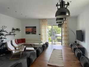 a living room with a couch and chairs and a tv at Traumhaus in der Eifel in Hellenthal