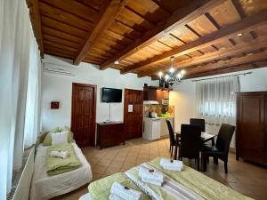 a room with two beds and a table and a kitchen at Cherry Apartmanház in Sárvár