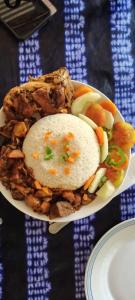 a bowl of food with rice and vegetables on a table at Campement Outouka in Kafountine