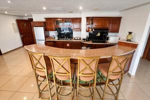 a kitchen with a large island with bar stools at Sand Rose Hotel Apartments in Al Khobar